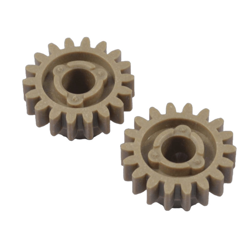 Two small beige plastic spur gears with central hubs and alignment tabs, placed diagonally against a dark background.