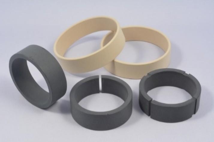 Set of gray and beige rubber rings and spacers of different sizes on a light background.
