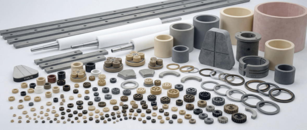 Assortment of precision gears, spacers, seals, and shafts laid out on a white surface for display or inspection.
