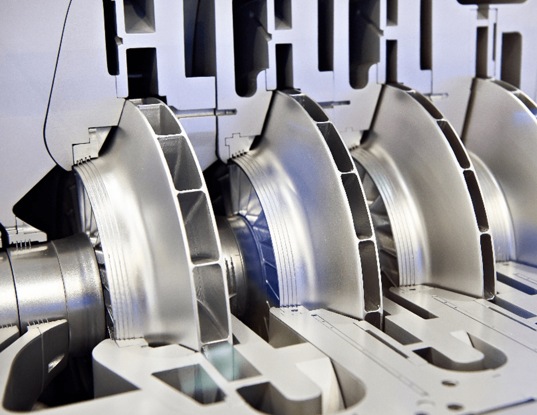 Close-up of three large metal circular blades in an industrial machine, showing precision cutting components and guide rails.